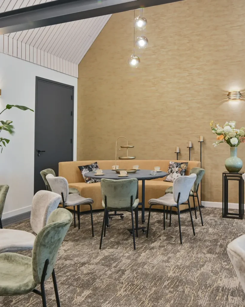 Ruimte voor de condoleance in 't Waerdsche Hof met tafels, stoelen en bloemen